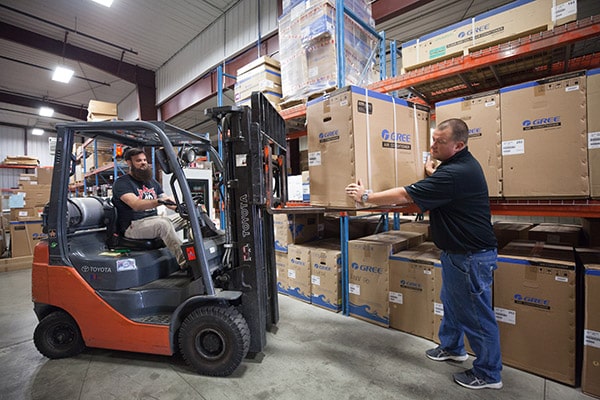 RHI Supply service staff loading HVAC equipment with forklift in warehouse for a customer.